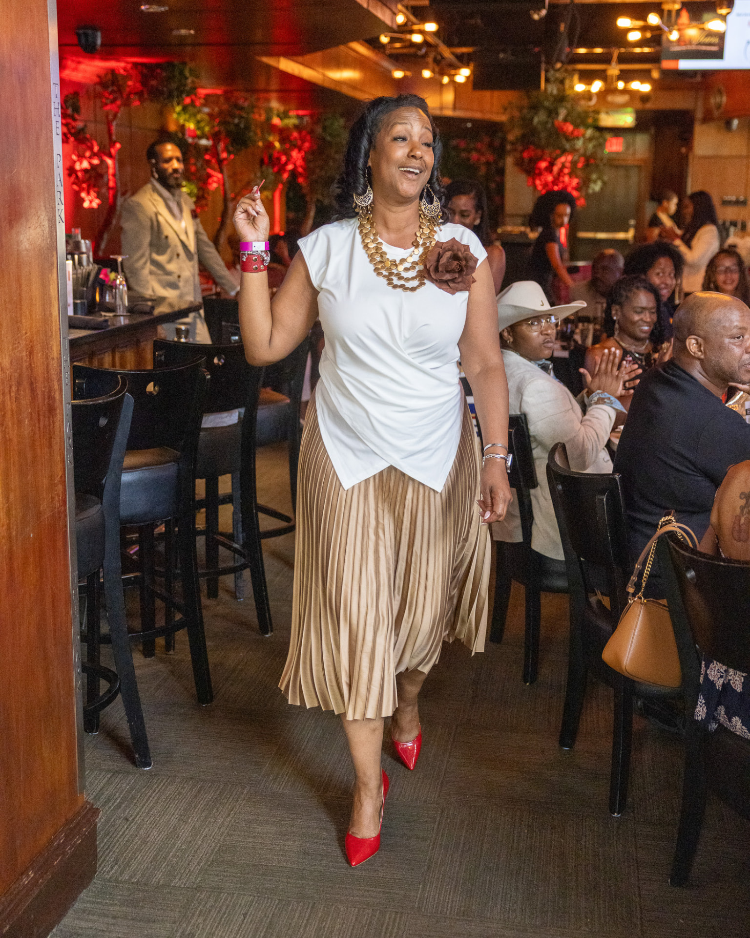 Guest walking through the dining room to applause during the brunch program