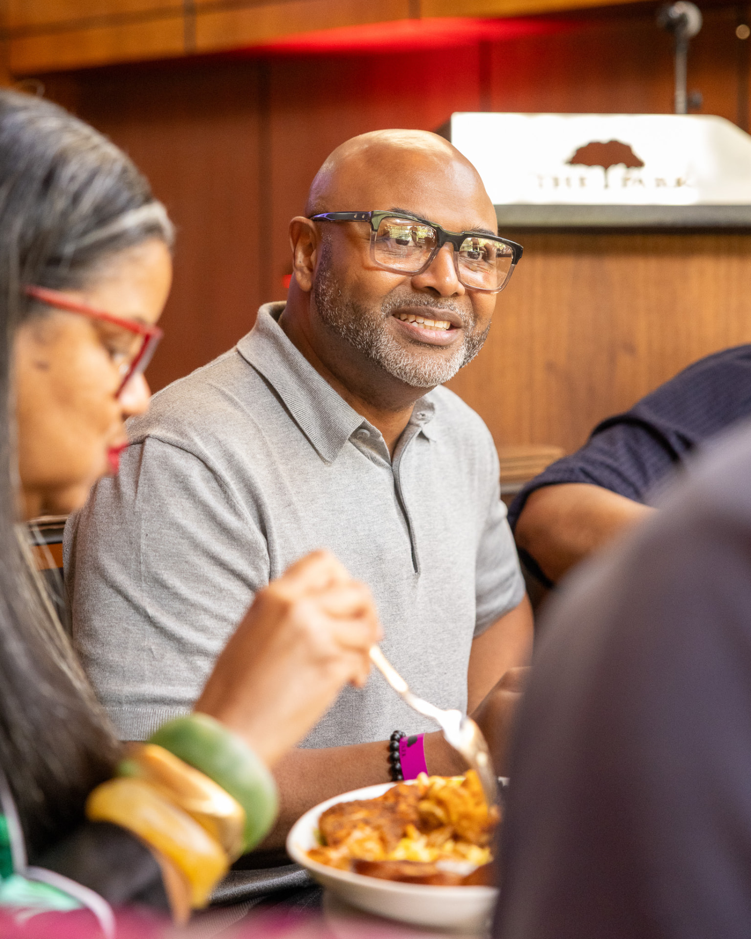 Guest in conversation over brunch beneath The Park at 14th sign