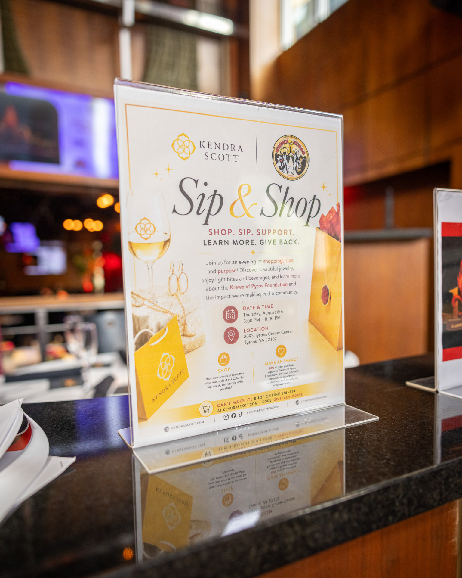 Kendra Scott Sip & Shop table sign benefiting the Krewe of Pyros Foundation