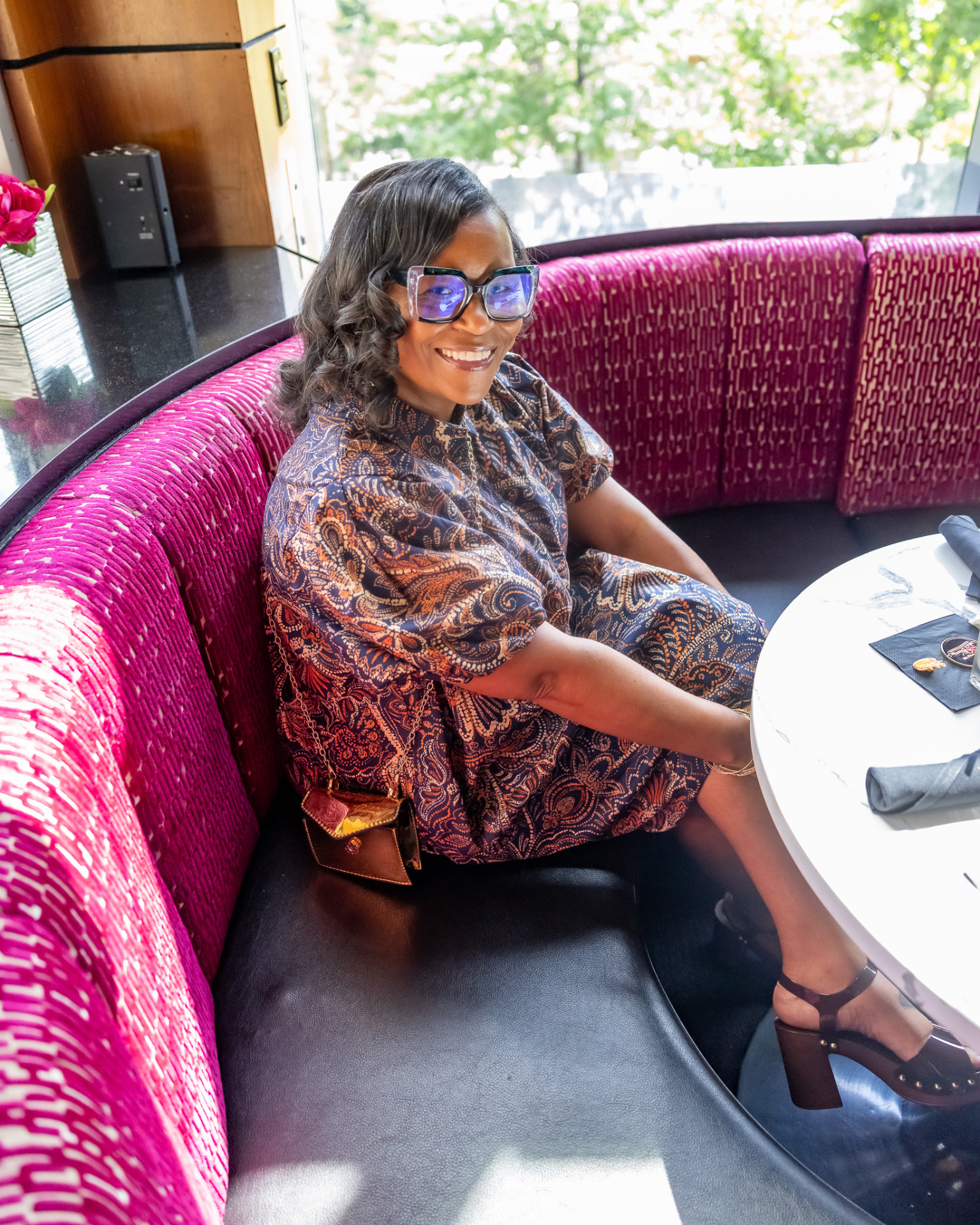 Guest seated in a magenta booth at the Krewe of Pyros Fundraising Brunch