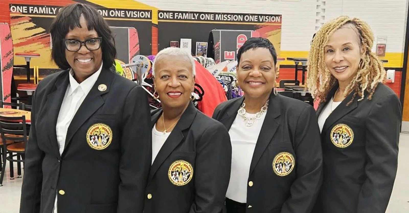 Four Krewe of Pyros members in crested black blazers at a high school prom shop