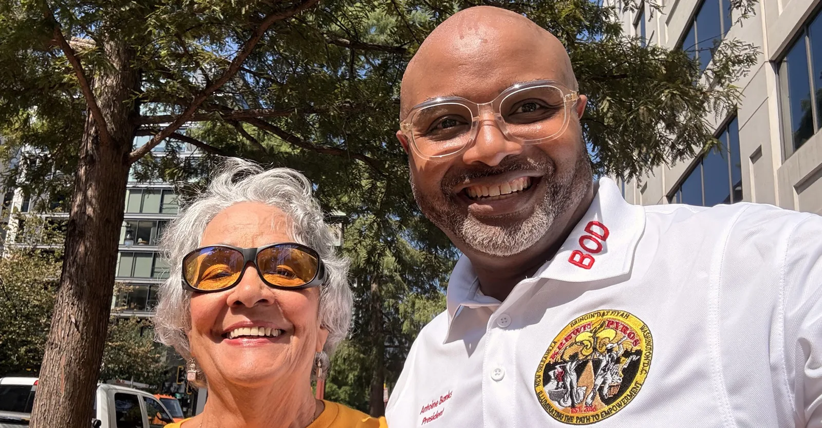 Krewe of Pyros president Antoine Banks with a community partner at an outdoor DC event