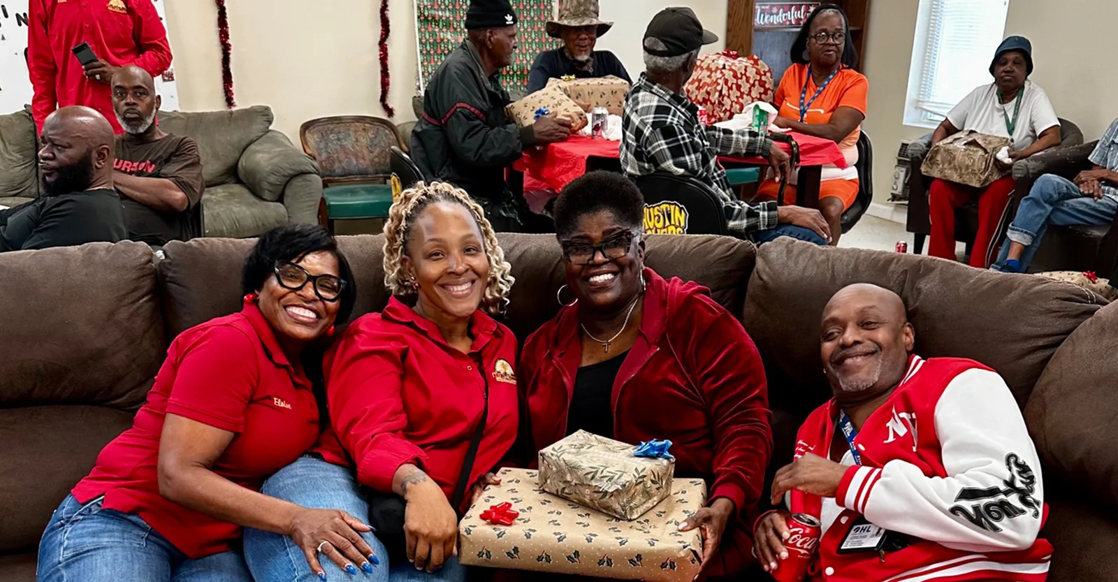Members sharing wrapped holiday gifts with residents at a community center