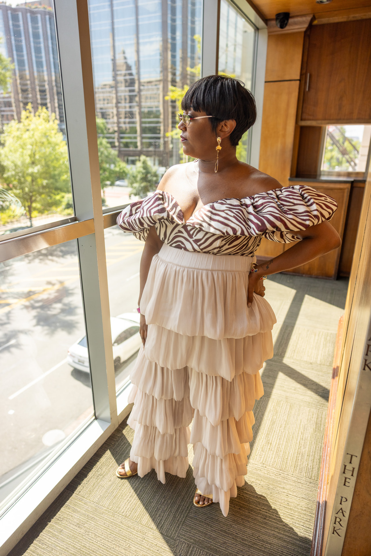 Guest in a tiered blush gown by the windows at The Park at 14th