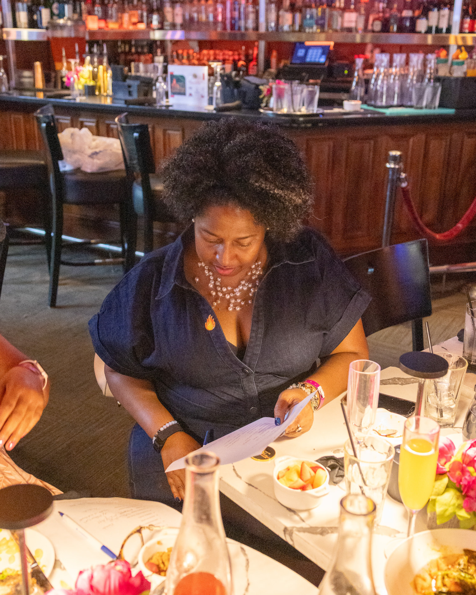 Guest reviewing the brunch program at a table set with mimosas and flowers