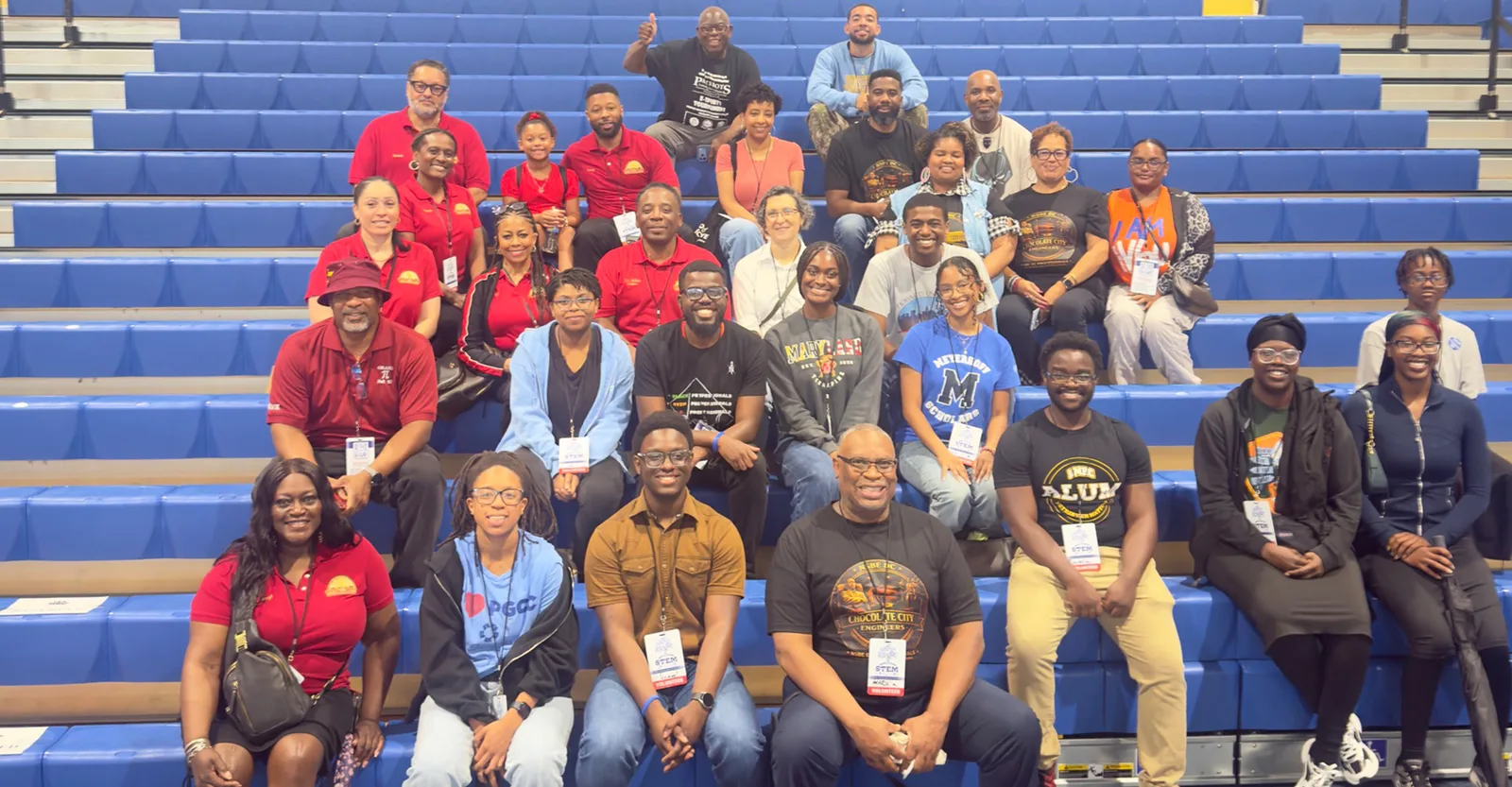 Krewe members and STEM festival volunteers gathered on gymnasium bleachers