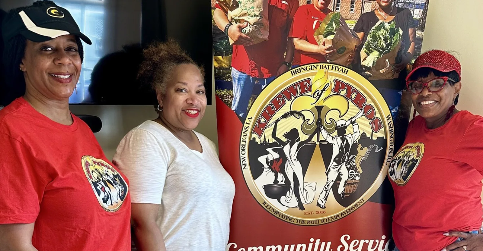 Members beside the Krewe of Pyros Community Service banner
