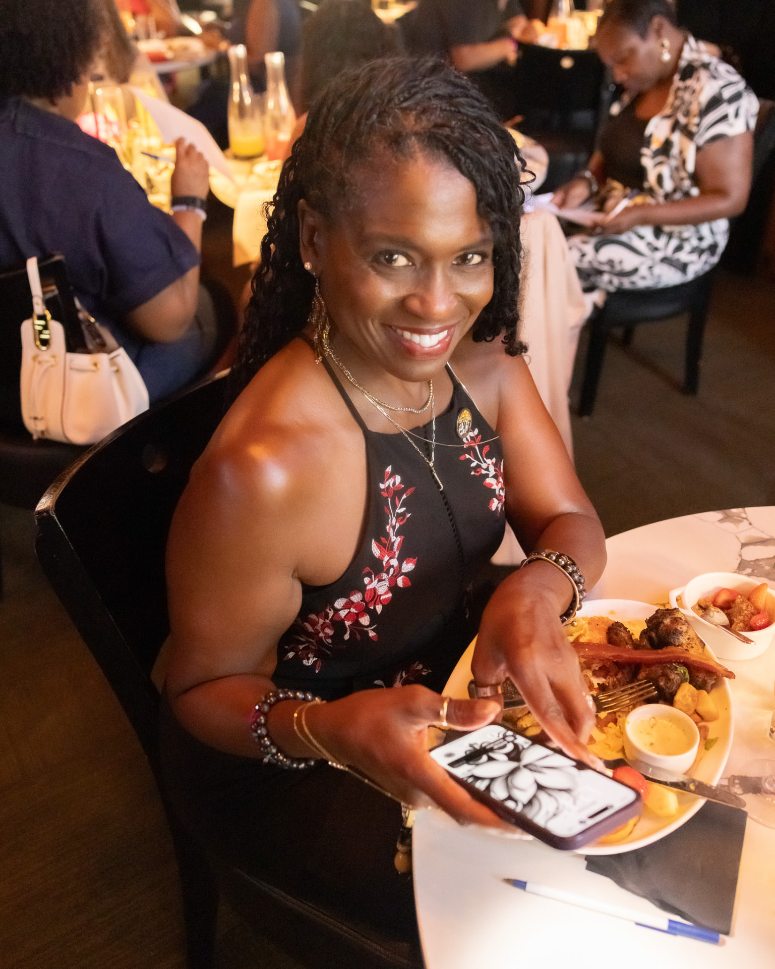 Guest with a Krewe of Pyros pin smiling over her brunch plate